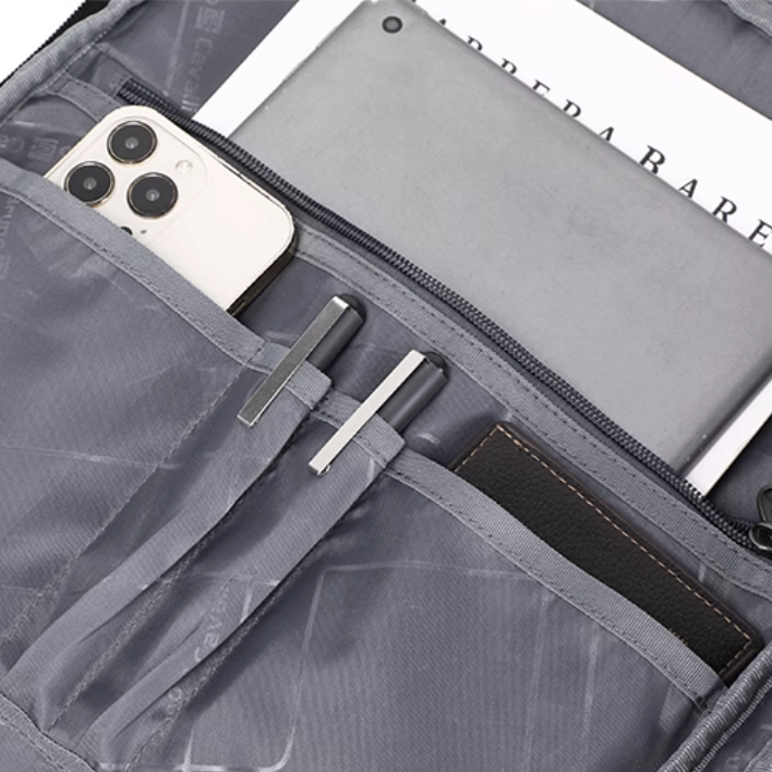 Gray travel organizer with compartments holding a phone, pen, and other items.